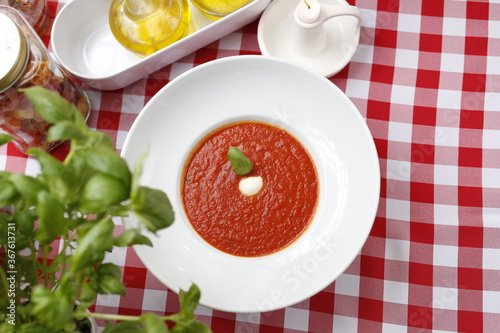  Tomato soup with basil and cream. Suggestion to serve a dish. Food background.