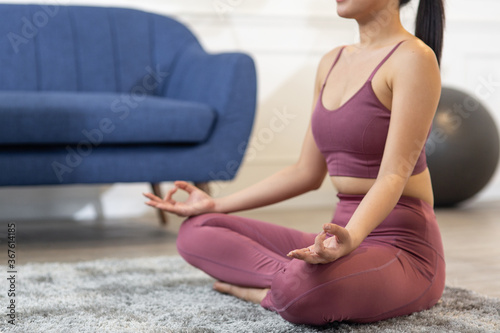 Close up Young Asian woman practicing yoga and meditating at home