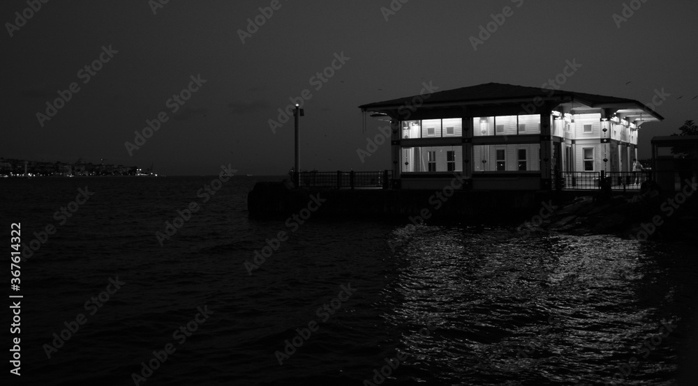 Pier lights at night. Reflection of lights. Black and white photo.
