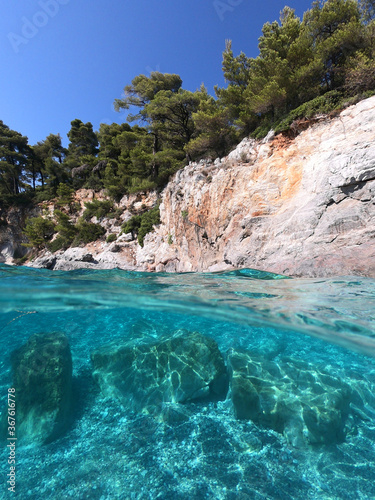 Sea level and underwater photo of caves and rocky nature in famous turquoise pebble beach of Kastani where famous Mamma Mia movie was filmed  Skopelos island  Sporades  Greece