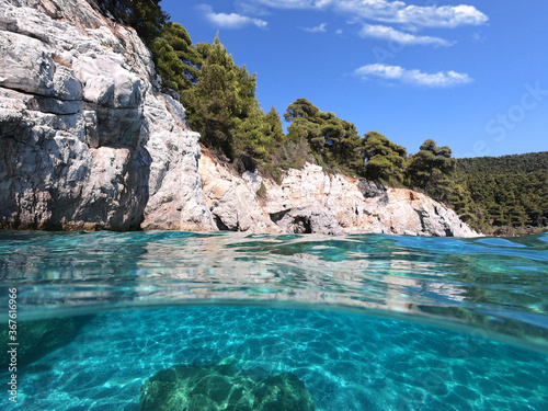 Sea level and underwater photo of caves and rocky nature in famous turquoise pebble beach of Kastani where famous Mamma Mia movie was filmed, Skopelos island, Sporades, Greece