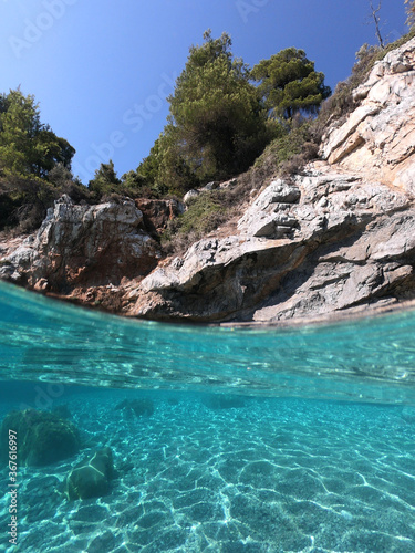 Sea level and underwater photo of caves and rocky nature in famous turquoise pebble beach of Kastani where famous Mamma Mia movie was filmed, Skopelos island, Sporades, Greece