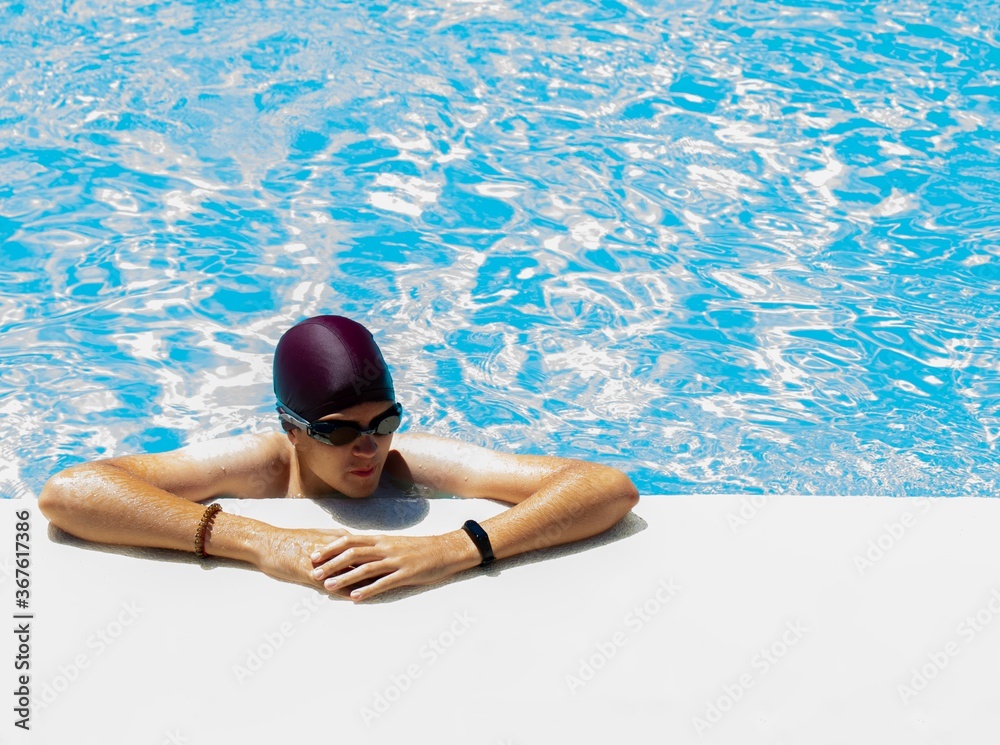 swimmer with glasses and cap at the edge of the refreshing pool ready to start training session