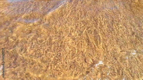Golden water waves, a river embankment at sunset, top view