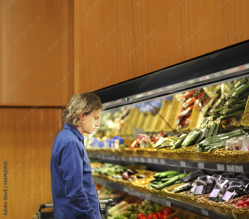 Supermarket shopping, man buying vegetables at the market