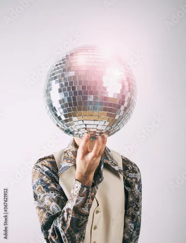 Fototapeta na wymiar 1970s Disco man in a leisure suit with a glittering disco mirror ball for a head