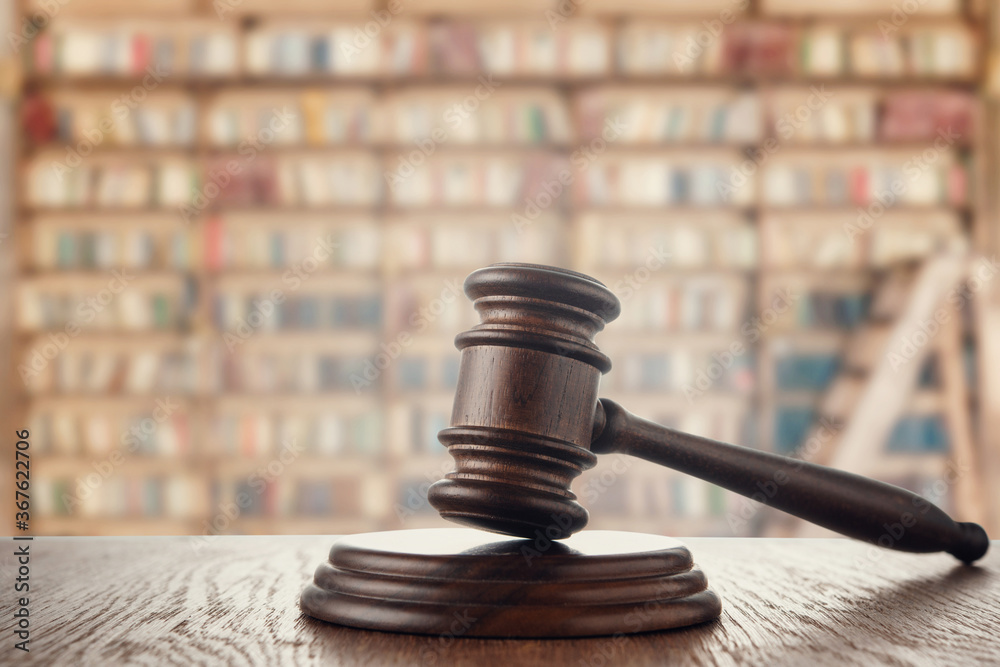 Judge (auction) gavel on the background of the library Judge (auction) gavel on the background of the library