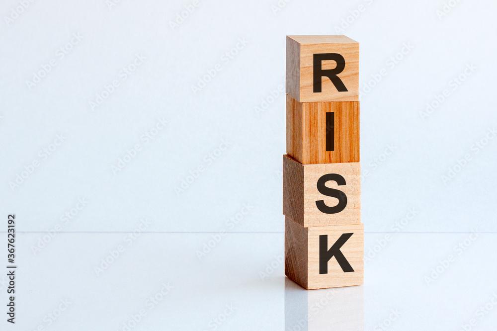 RISK cube wooden blocks on white table background. Home, Crisis, Economic recession, Buy concept. Free space on the left