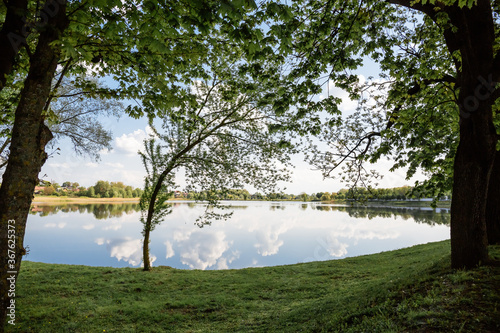Beautiful view of the lake with a mirror reflection, in clear sunny weather. Belarus. Park Nesvizh. Historical attraction. © Hanna
