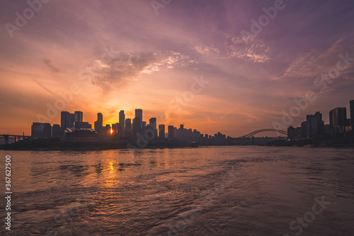 Silhouettes of buildings surrounded by the Yangtze river under the sunlight during the sunset in Chongqing