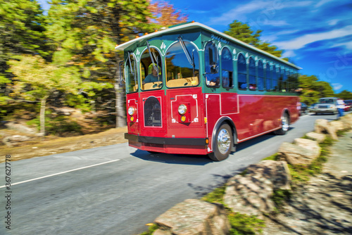 Speeding up red trolley in Acadia National Park, Maine photo