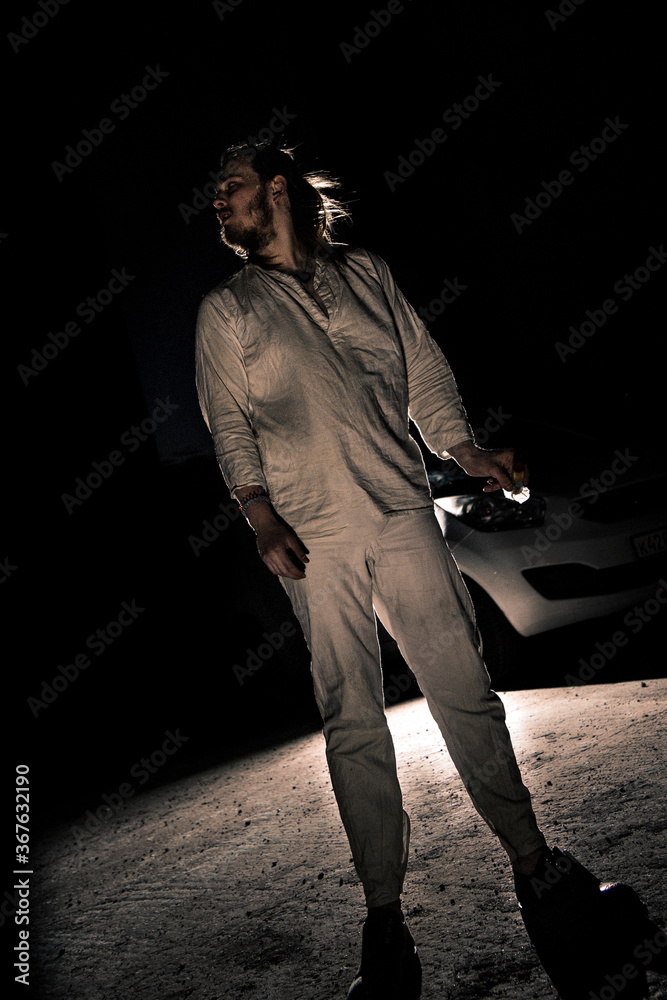 A man in white flax costume and colored smoke. Dark background A man in white flax costume and colored smoke. Dark background