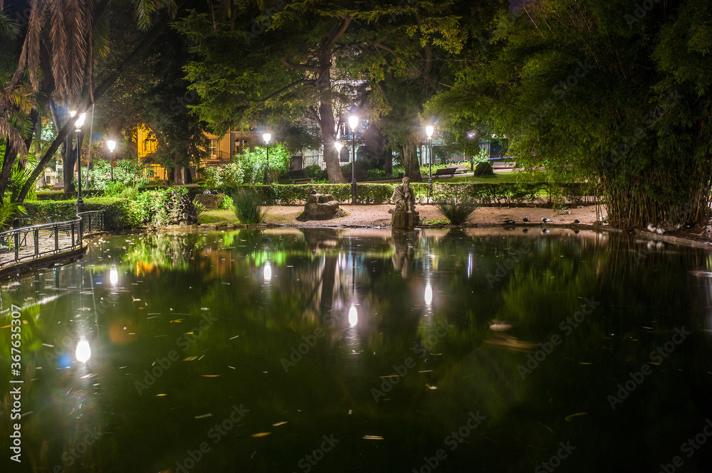 Night view of the lake in the public Estrela Garden in Lisbon, Portugal 
