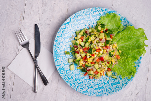 Hawaii style vegetarian raw eating salad.  served in beautiful blue plate on white table. flat lay photo