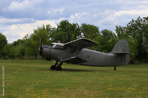 Classic old retro vintage airplane with a propeller at a green airfield photo