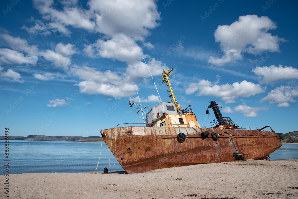Bright rusty old abandoned fishing boat on the coast