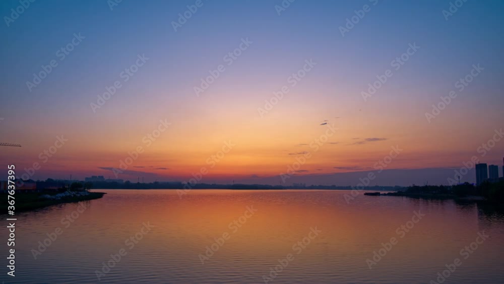 Time-lapse of sunrise in skyline, reflections on lake, panorama Time-lapse of sunrise in skyline, reflections on lake, panorama
