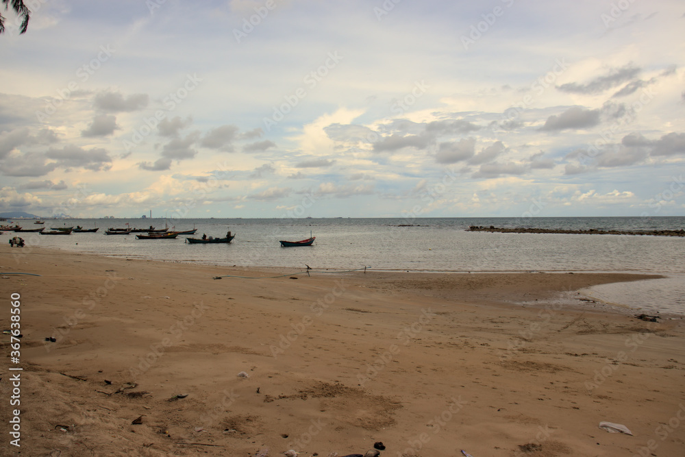 Peaceful beach with fishing boats moored in the harbor