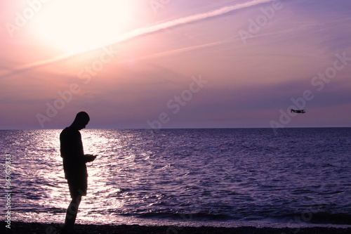 Silhouette of a man along the sunset beach