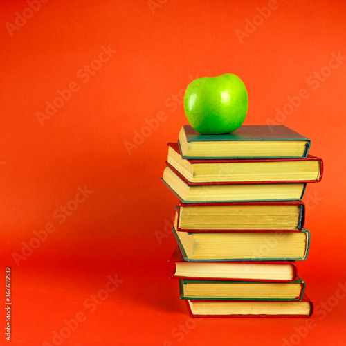 stack of books and green apple. symbol of knowledge and study, education and development. space for text