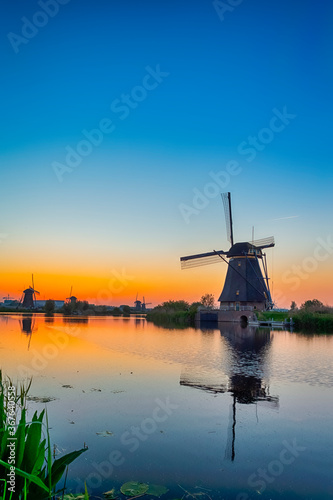 European Travel Destinations. Traditional Romantic Dutch Windmills in Kinderdijk Village in the Netherlands During Golden Hour.