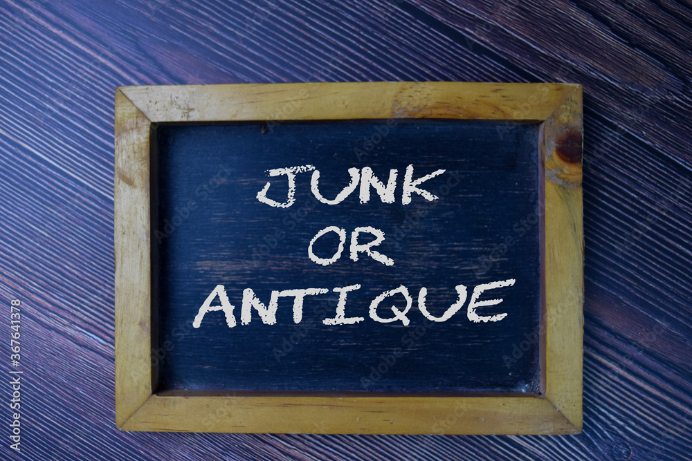 Junk or Antique text write on chalkboard isolated on office desk.