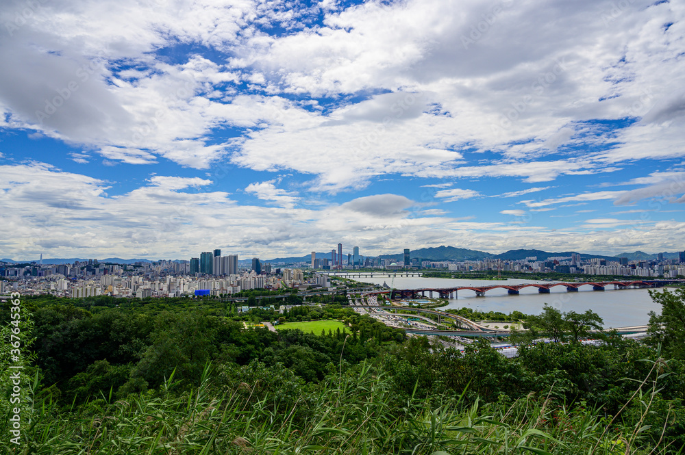 Landscape of Seoul City, modern building  and han river with traffic on bridge seen  from Haneul park.at summer in south korea