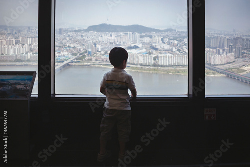 A child looking at the city from a high tower © Jacky