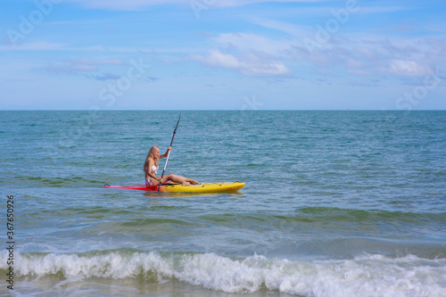 Woman Kayaking in the Ocean on Vacation © sutthichai