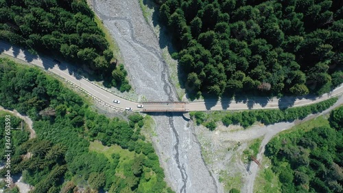 Cars Crossing On The Bridge In Shovi, Region Of Racha In Georgia On A Sunny Day - top-down aerial shot photo