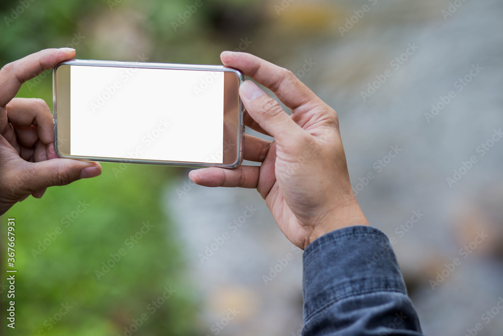 Cropped shot view of man holding smart phone with blank copy space screen for your text message or information content blurred background.
