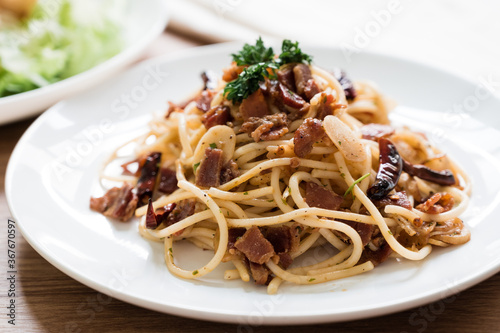 Spaghetti bacon chilli garlic in a round white dish