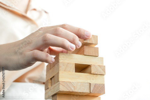 Hands of businesswomen playing wooden block game. Concept Risk of management and strategy plans for business growth and success
