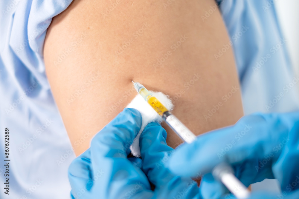 Female doctors vaccinated with syringes to prevent epidemics at hospitals, health care, and medical concepts Female doctors vaccinated with syringes to prevent epidemics at hospitals, health care, and medical concepts
