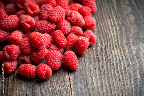 Freshly harvested raspberry on the rustic wooden background. Selective focus. Shallow depth of field.