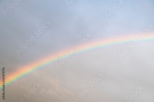 Sky rainbow. Sky rainbow over the clouds. Rainbow sky landscape. Rainbow background. Rainbow sunset. Beautiful colourful rainbow in the sky. © Aleksei