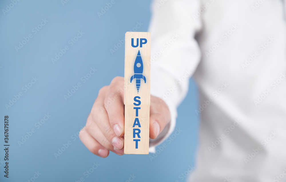 Man showing rocket on wooden block. Business. Startup Man showing rocket on wooden block. Business. Startup