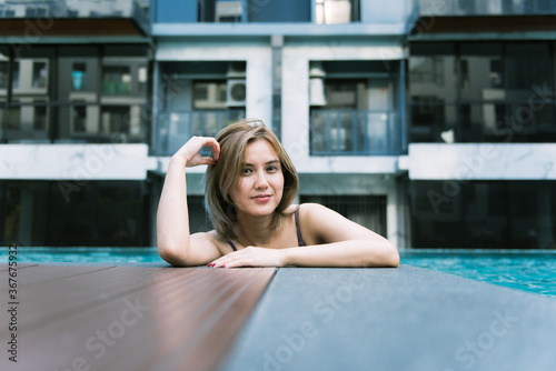 Beautiful young asian woman smiling in a swimming pool.