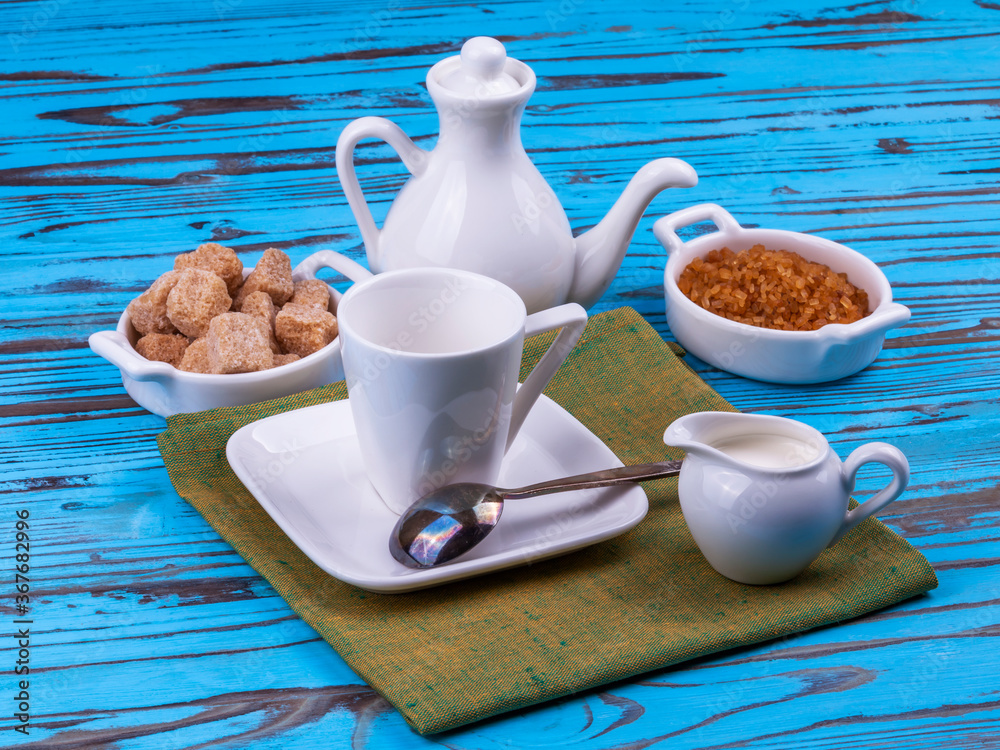 Table setting for coffee. Milk jug, coffee pot, and small saucers with