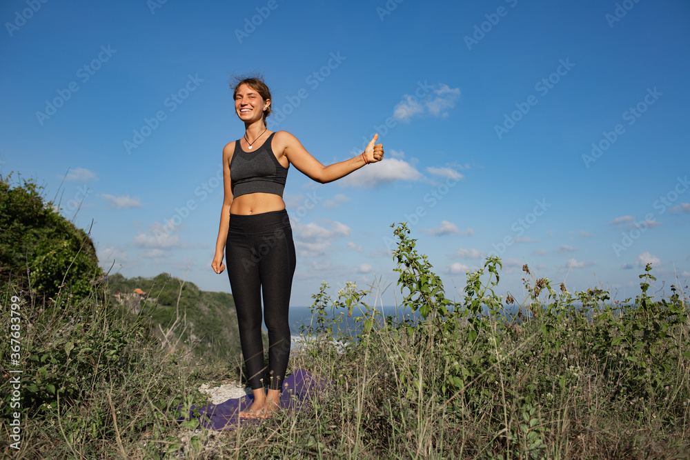Young woman doing yoga outdoors with amazing back view. Bali. Indonesia. Young woman doing yoga outdoors with amazing back view. Bali. Indonesia.