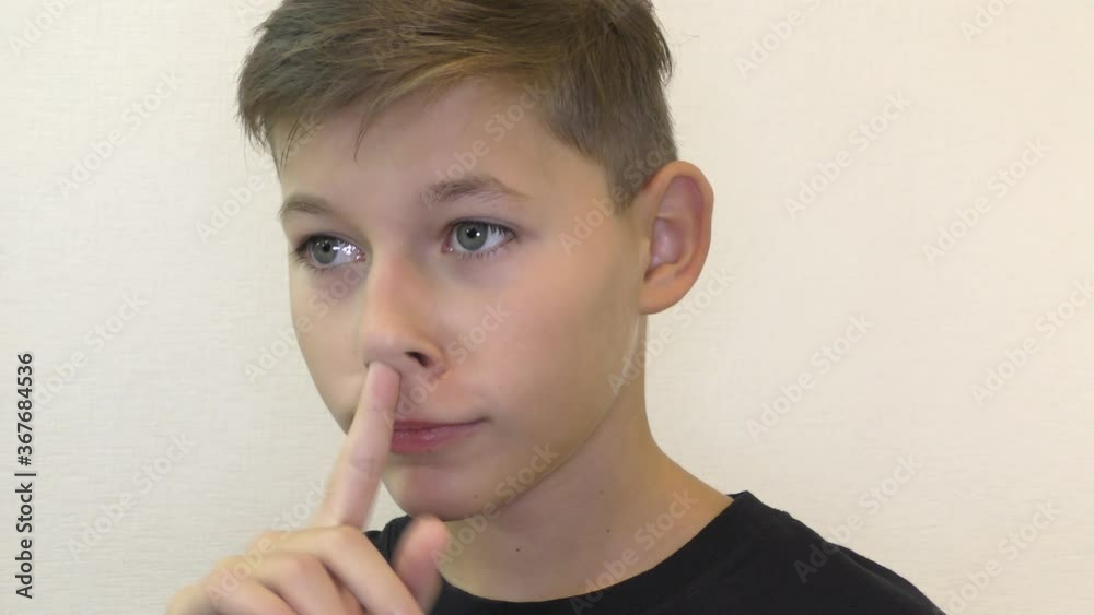 A young man of European appearance picks his finger in his nose. A young man of European appearance picks his finger in his nose.