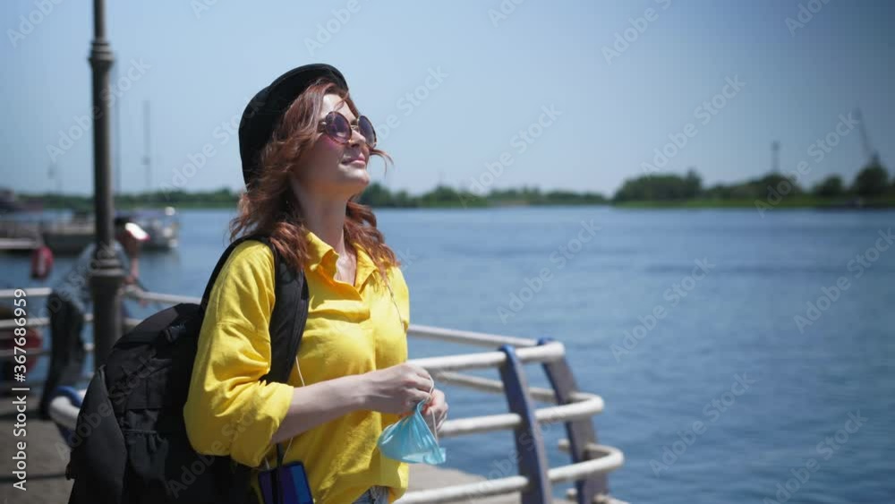 quarantine release, happy young woman cheers after border opening and takes off her medical mask to protect herself from virus and infection while enjoying walk outdoors quarantine release, happy young woman cheers after border opening and takes off her medical mask to protect herself from virus and infection while enjoying walk outdoors