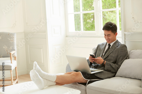 Canvas Print young asian corporate executive working from home reading text messages on mobil