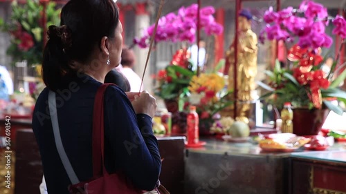 Woman praying and burning incense at the Lungshan Temple in Taipei 