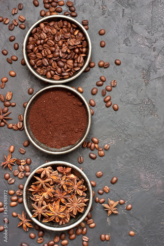 Coffee beans, milled coffee and spices on dark background