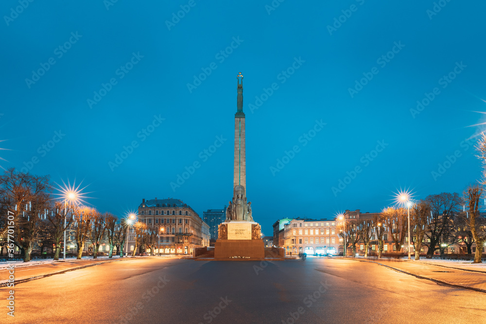 Riga, Latvia. Night View Of Memorial Freedom Monument At Freedom Square In Night Lighting Illumination