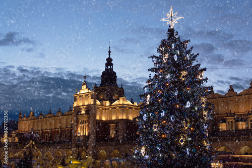 Large christmas tree illuminated at night standing on the Main Market Square in Krakow.