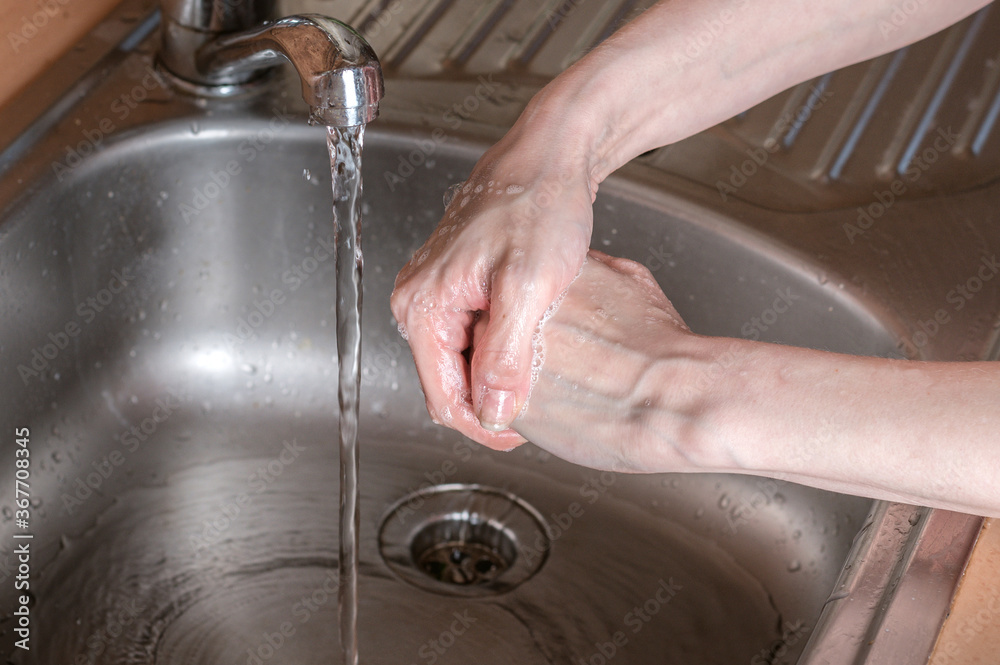 Woman use soap and washing hands under the water tap