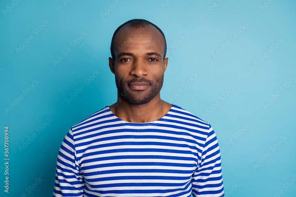 Portrait of charismatic dark skin guy travel trip look in camera feel minded peaceful wear striped sailor vest isolated over blue color background Portrait of charismatic dark skin guy travel trip look in camera feel minded peaceful wear striped sailor vest isolated over blue color background