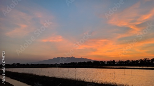 Fototapeta Naklejka Na Ścianę i Meble -  The sun sets over the ponds and beautiful sky
